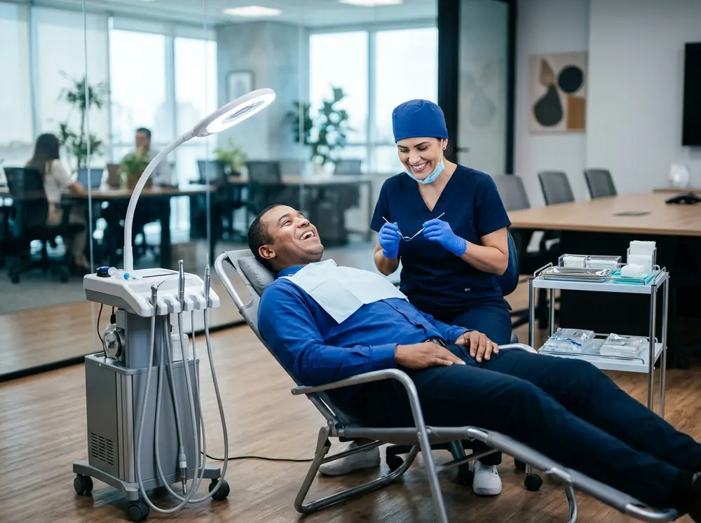 Dentista atendendo um funcionário em consultório odontológico móvel montado numa sala de reunião da empresa
